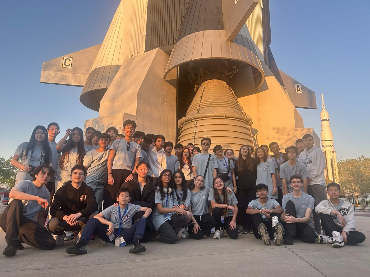 Rebel Robotics students near the Saturn V rocket during the Rocket City trip.